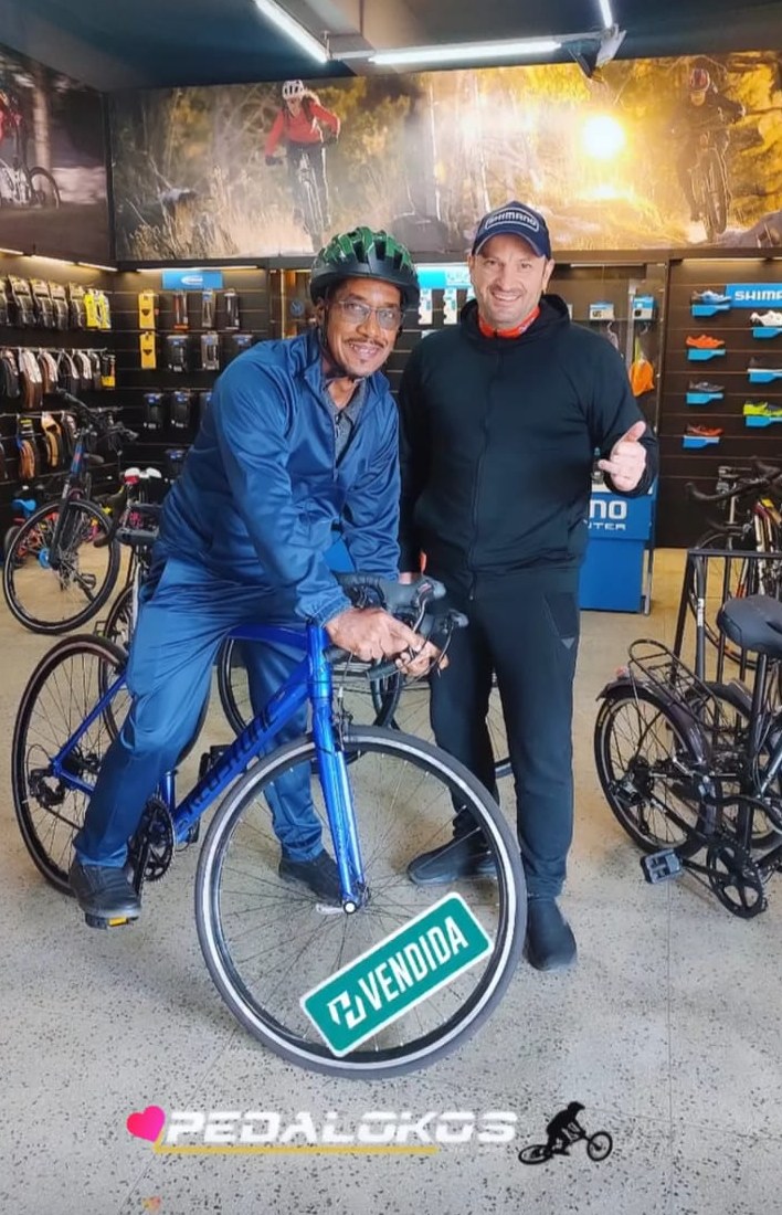 Cliente experimentando bicicleta urbana azul recém comprada na loja