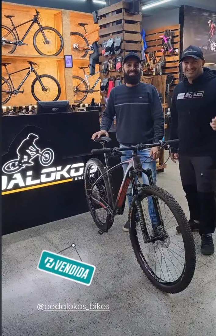 Cliente com mountain bike cinza e vermelha após escolher o tamanho correto de quadro