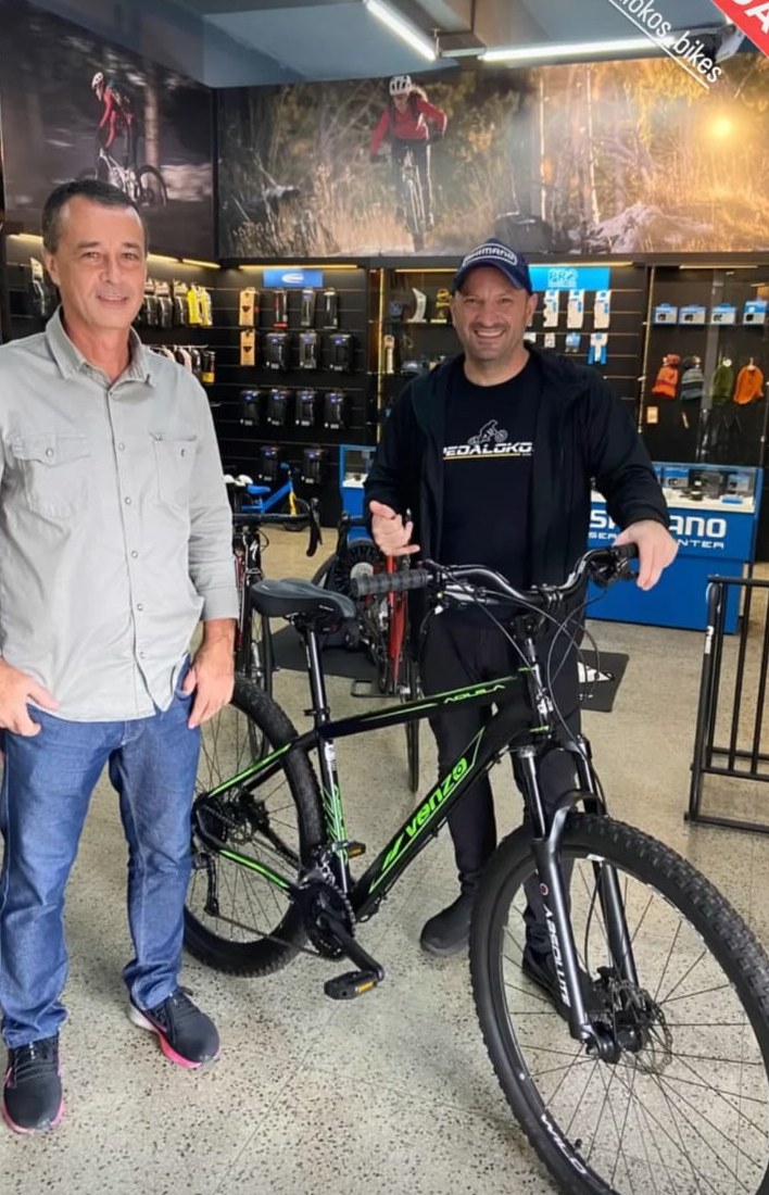 Cliente com mountain bike preta e verde escolhida para trilhas