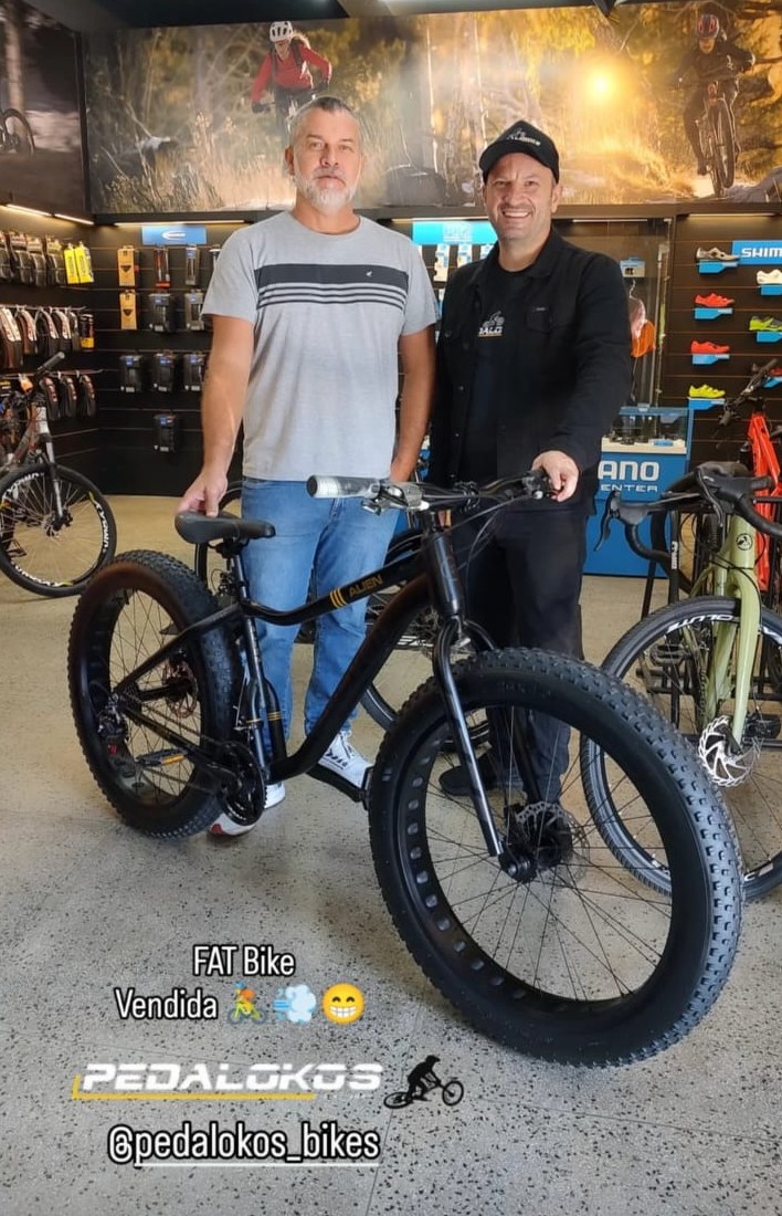 Cliente com fat bike preta de pneus largos entregue na loja