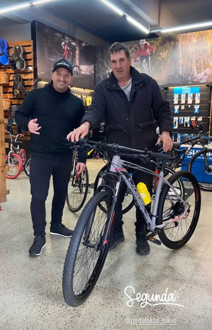 Cliente com mountain bike cinza escolhida para pedais de fim de semana