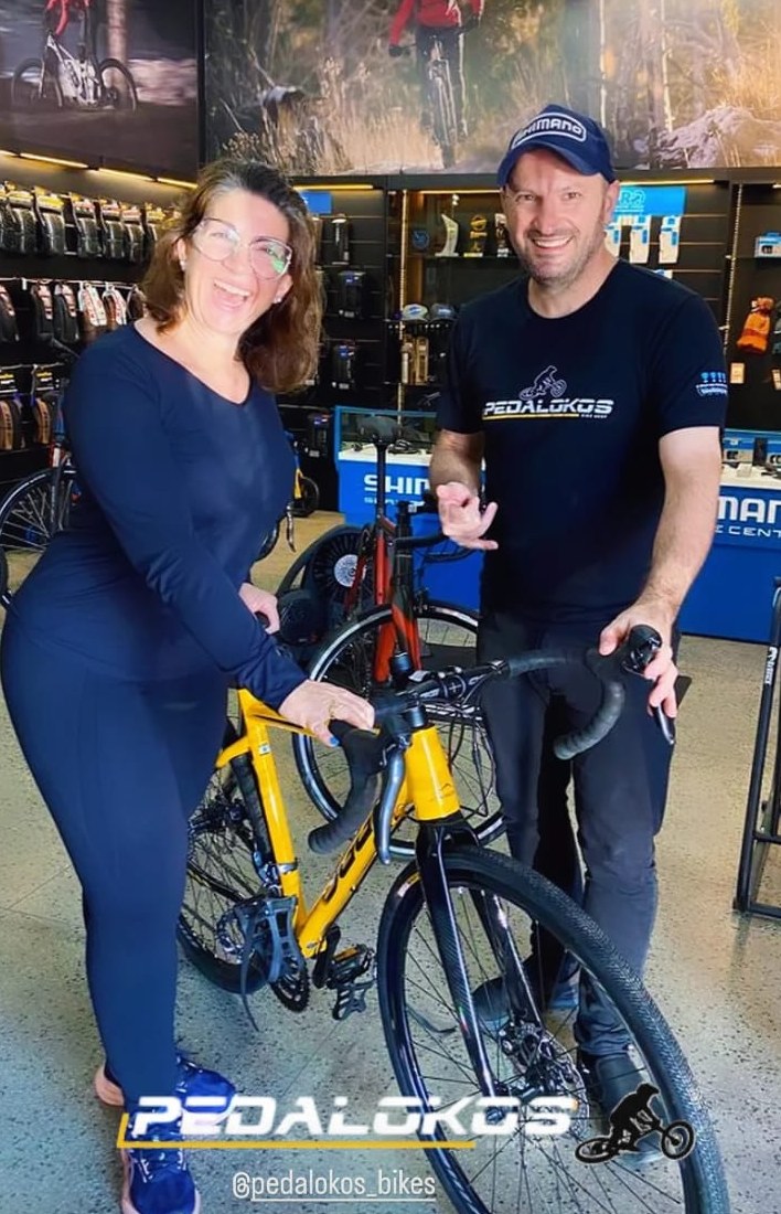 Cliente com bicicleta speed amarela escolhida para pedais na estrada