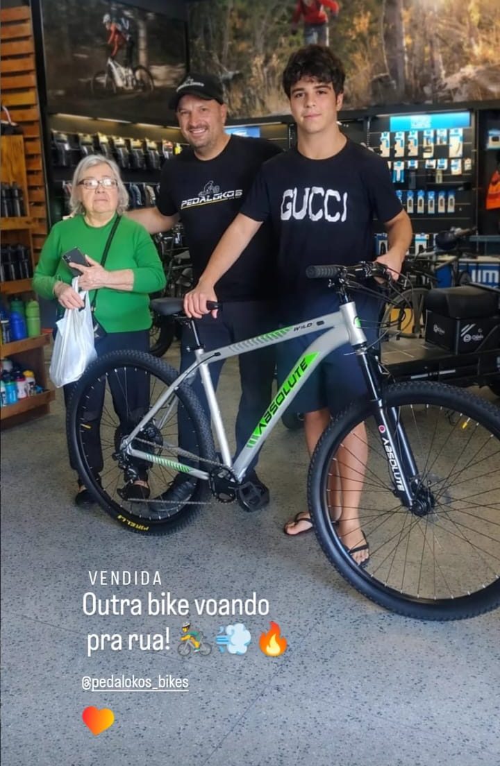 Família recebendo mountain bike Absolute prata na loja Pedalokos