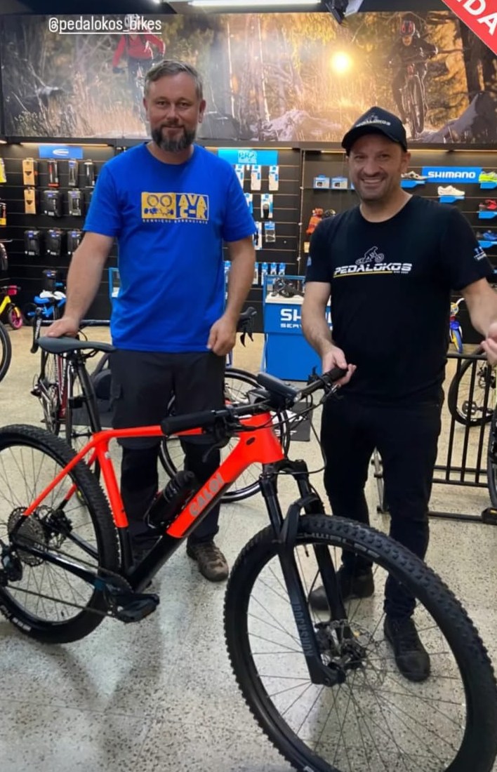 Cliente com mountain bike vermelha de aro 29 comprada com atendimento do Matheus