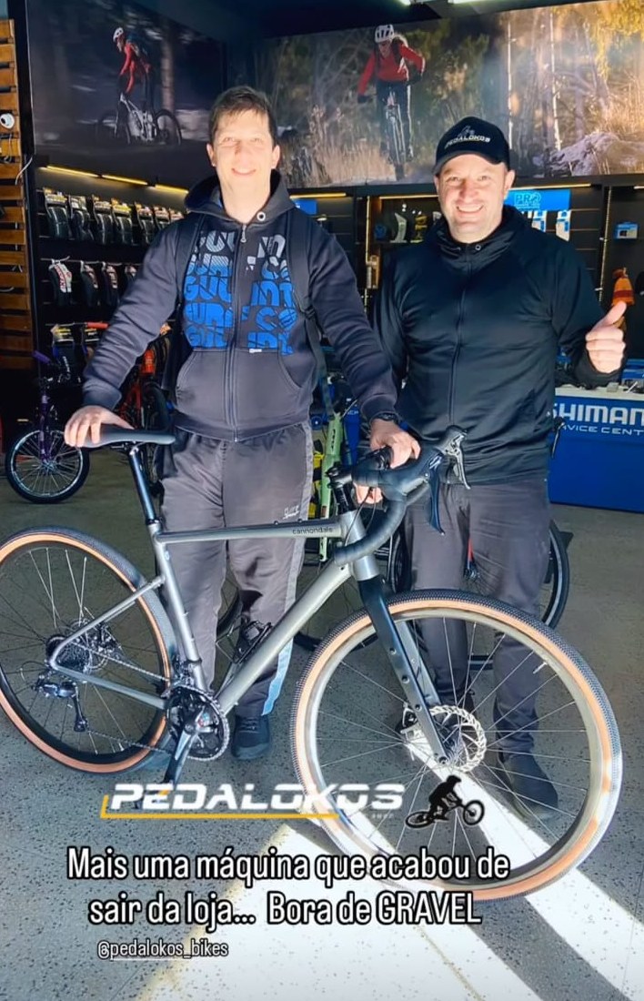 Cliente com bicicleta gravel cinza de pneus marrons entregue na loja