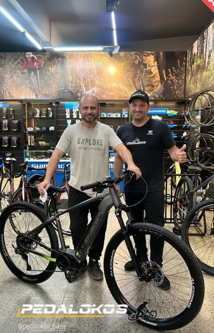Cliente com e-bike de mountain bike cinza entregue na loja