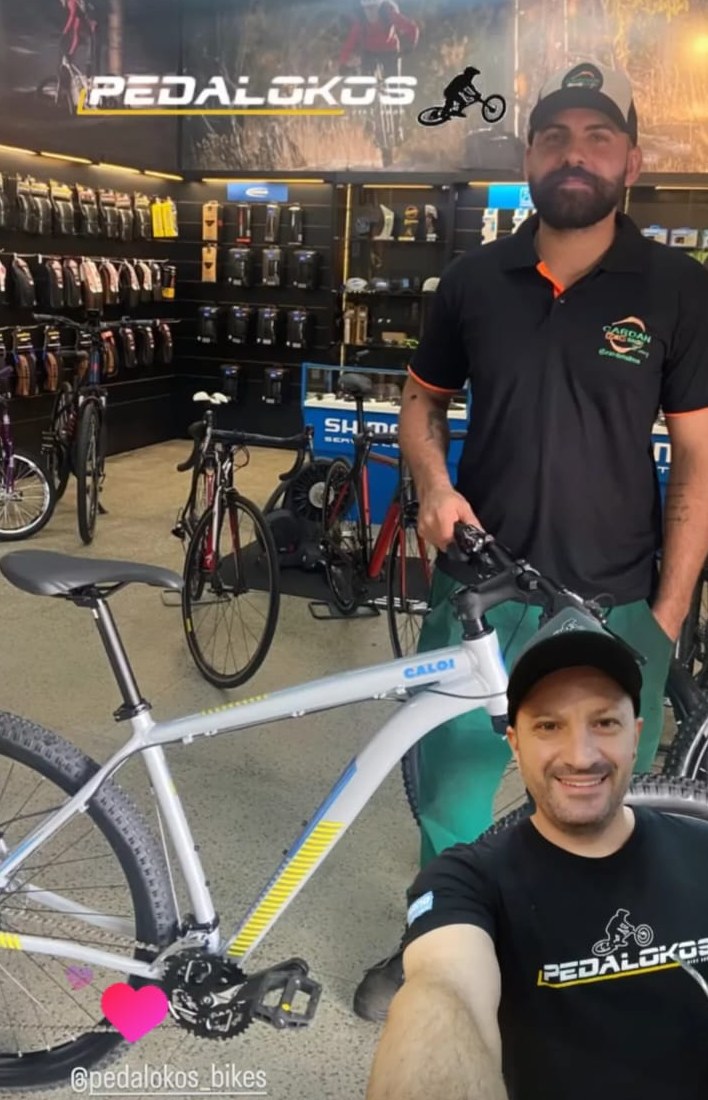 Cliente com mountain bike Caloi branca entregue pronta para rodar